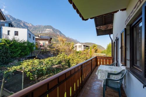 a balcony with a table and a chair on it at Apartments Burgunderhof in Termeno