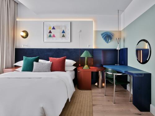 a hotel room with a bed and a desk at Kimpton Main Frankfurt by IHG in Frankfurt