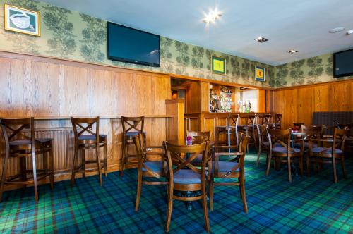 a restaurant with wooden walls and chairs and a bar at South Beach Hotel in Troon