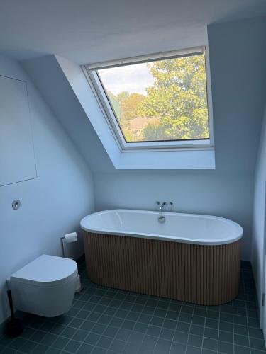 a bathroom with a bath tub and a window at The Old Manse, Horton in Horton