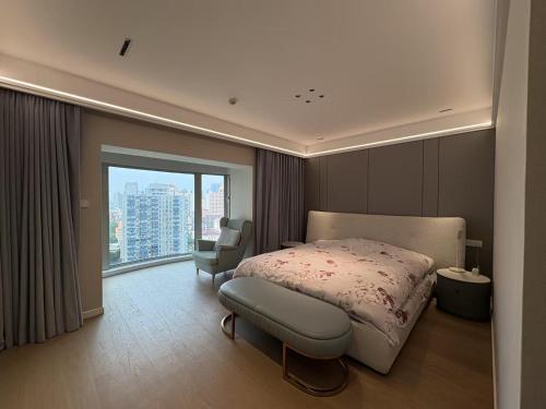 a bedroom with a bed and a chair and a window at iHome-Lujiazui Riverside, Bund Riverview, Skyscrapers Citywalk, EUMake Deluxe Shanghai Living, As Pictured in Shanghai