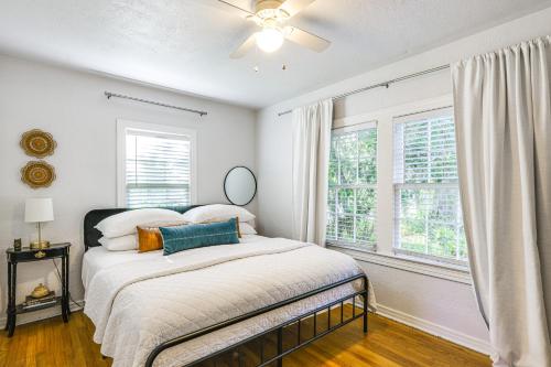 a white bedroom with a bed and two windows at ~ 12 Mi to Disney: Downtown Winter Garden Cottage! in Orlando