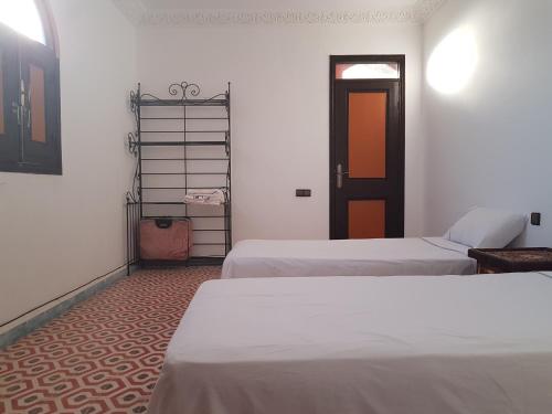 a room with two beds and a door at Atlas Resorts in Aït Ourir