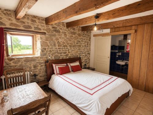 a bedroom with a bed and a table and a sink at Chambres d'Hôtes du Manoir du Haut Salmon in Saint Malo