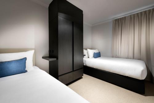 Una cama o camas en una habitación de Tradewinds Hotel and Suites Fremantle