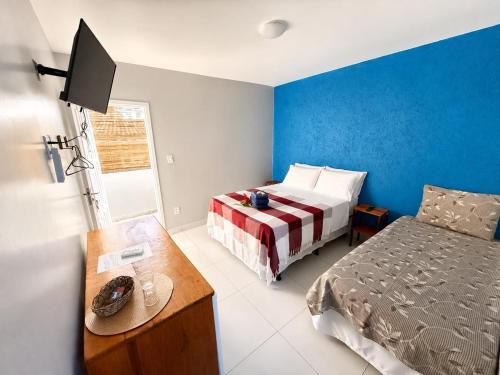 a bedroom with a bed and a desk and a bed sidx sidx sidx at Pousada Rainha do Mar in Ilha de Boipeba