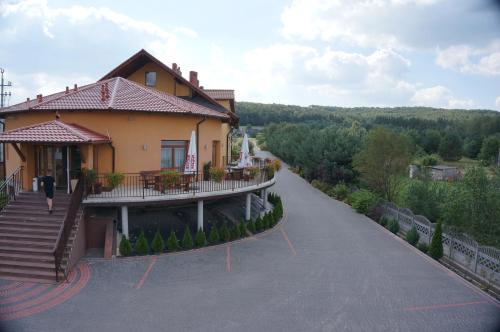 a house with a balcony on a road at Hotel & Restauracja Okrąglak in Chęciny