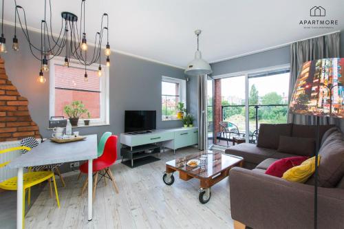 a living room with a couch and a table at City Center - AURA by Apartmore in Gdańsk