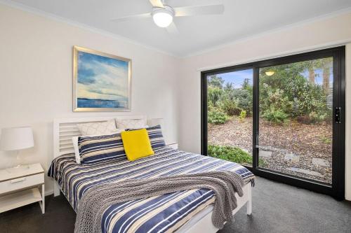 a bedroom with a bed and a large window at BYO Linen - Aireys Delight in Aireys Inlet