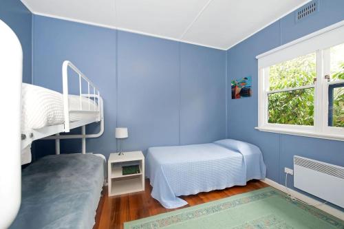 a blue room with two beds and a window at Anderson in Apollo Bay