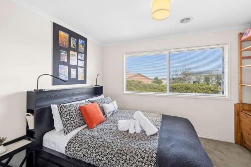 a bedroom with a black and white bed and a window at Beach Living Bliss in Torquay