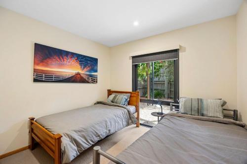 a bedroom with two beds and a window at Blue Water - BYO Linen in Anglesea