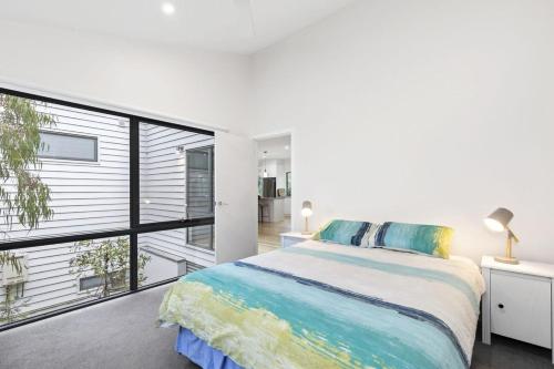 a bedroom with a bed and a large window at Alto Vista in Lorne