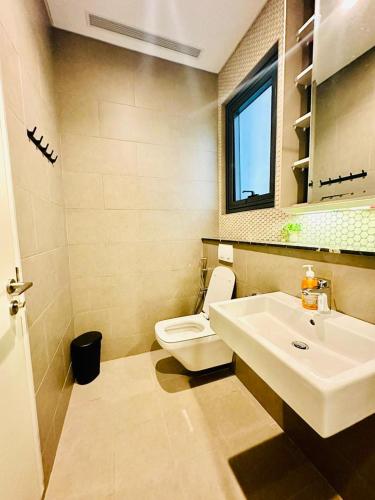 a bathroom with a white toilet and a sink at Lucentia Residence BBCC Modern City View Stay in Kuala Lumpur