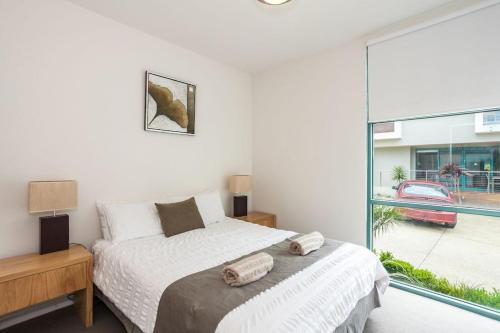 a bedroom with a bed and a large window at Anglesea River Apartment 22 in Anglesea