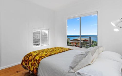 a bedroom with a bed with a large window at Blue Surf - BYO Linen in Apollo Bay