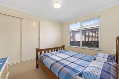 a bedroom with a bed and a window at Budget By The Bay in Apollo Bay