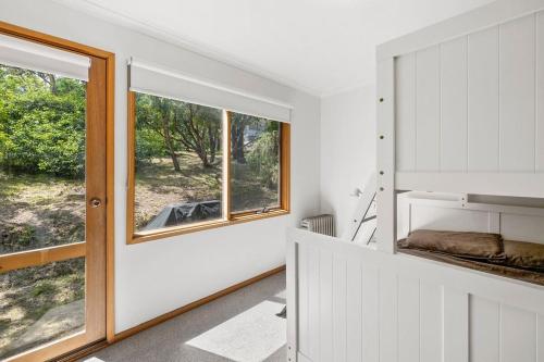 a bedroom with white walls and a window at Atwood in Aireys Inlet