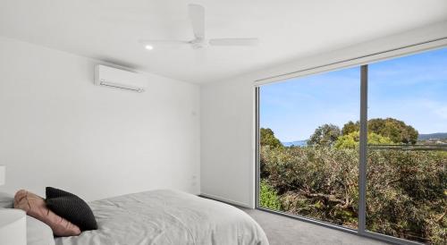 a bedroom with a bed and a large window at Aireys Sunset Beach House in Aireys Inlet