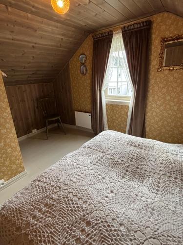 a bedroom with a bed and a window at Gammel stua AS in Andøya