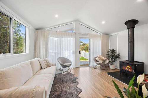 a living room with a couch and a fireplace at AquaLuna Beach House in Aireys Inlet