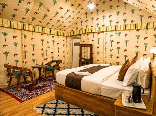 a bedroom with a bed in a room with palm wallpaper at Desert Luxury Camp & Resort Jaisalmer in Jaisalmer