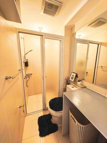 a bathroom with a toilet and a shower in it at Z Crib - Azure North in San Fernando