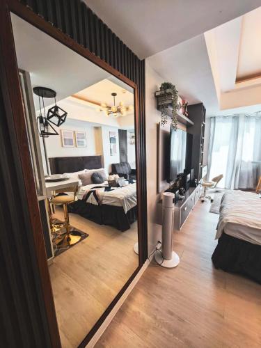 a room with two beds and a mirror at Z Crib - Azure North in San Fernando