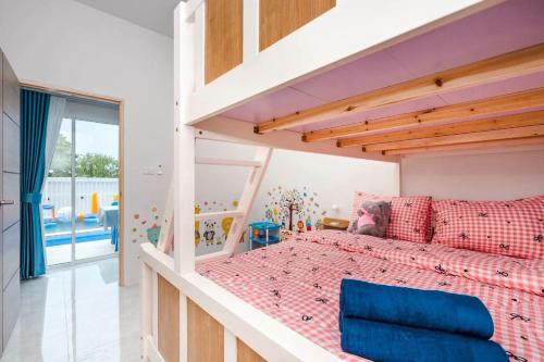 a bedroom with a bunk bed with a blue chair at Good Pool Villa Luxury in Ban Hui Yai Muk