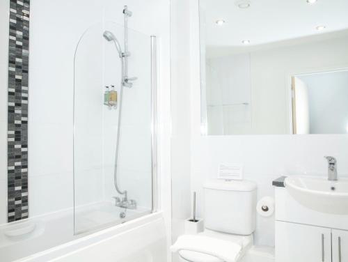 a bathroom with a shower and a toilet and a sink at Oakdale at Centrium in Woking