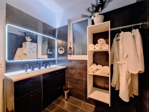 a bathroom with a sink and a mirror and towels at L'antre Parenthèse 46 in Souillac