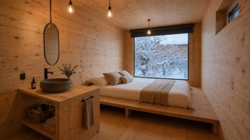 a bedroom with a bed and a large window at Hostel del Lago, habitaciones privadas y cabañas in El Chalten