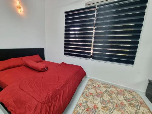a bedroom with a red bed and a window at HomeStay with Serene Surrounding in Nibung Tebal