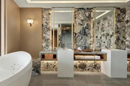 a bathroom with a tub and a sink at Beijing Marriott Hotel Huairou in Huairou