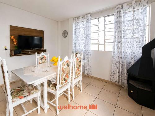 a dining room with a white table and chairs at Cobertura com Vista e Conforto no RS in Santo Ângelo