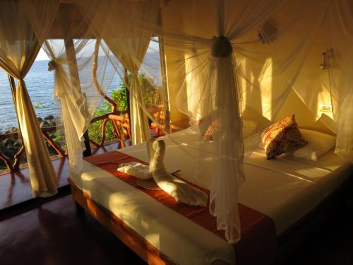 - une chambre avec un lit et une vue sur l'océan dans l'établissement Camiguin Volcan Beach Eco Retreat & Dive Resort, à Mambajao