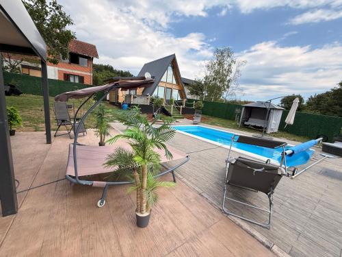 a patio with a swimming pool and a pool at A-Frame Wellness Villa with Private Pool, Sauna & Jacuzzi near Belgrade in Koraćica