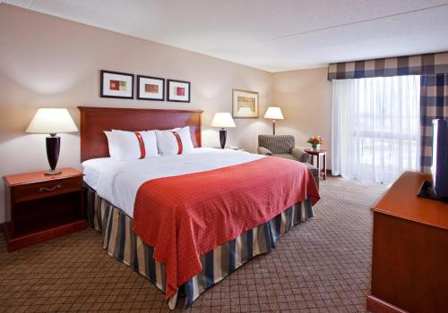 a hotel room with a bed and a television at Holiday Inn Cincinnati-Eastgate by IHG in Eastgate
