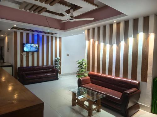 a living room with two leather couches and a tv at HOTEL AL SAFA INTERNATIONAL, Ashkona in Dhaka