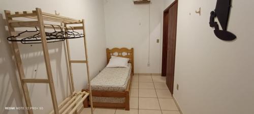 a small room with a bunk bed and a ladder at Residencial Sol de Ibiraquera in Barra de Ibiraquera