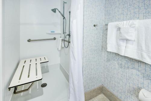a white bathroom with a shower and a sink at Holiday Inn Express Woodbridge by IHG in Avenel