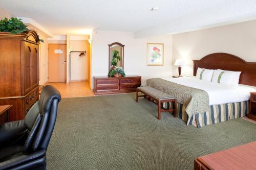 a hotel room with a large bed and a chair at Holiday Inn Great Falls-Convention Center by IHG in Great Falls