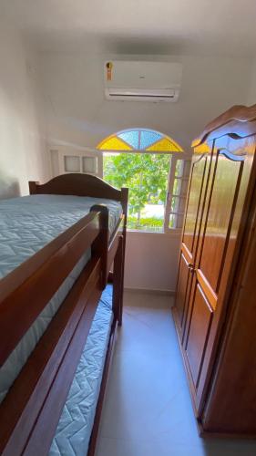 a bedroom with two bunk beds and a window at Residencial Sombreiro - a 50 m da praia in Florianópolis
