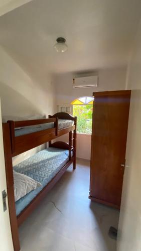 two bunk beds in a room with a window at Residencial Sombreiro - a 50 m da praia in Florianópolis