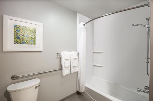 a white bathroom with a toilet and a bath tub at Holiday Inn Express Hotel & Suites Columbus by IHG in Columbus