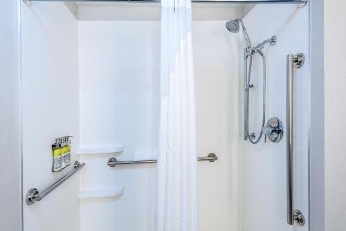 a shower with a shower curtain in a bathroom at Holiday Inn Express Hotel and Suites Bastrop by IHG in Bastrop