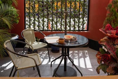 a table and chairs on a patio with a window at Kontiki Miraflores in Lima