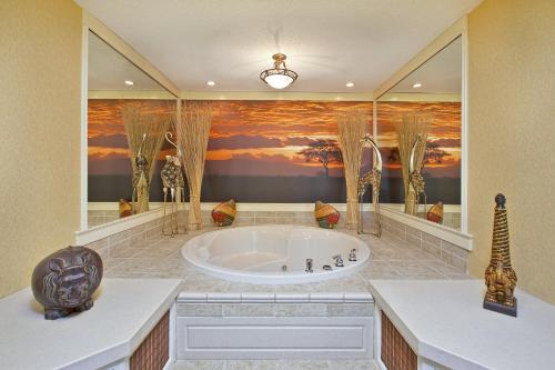 a bathroom with a large tub with a painting on the wall at Holiday Inn Express & Suites - Sharon-Hermitage by IHG in West Middlesex