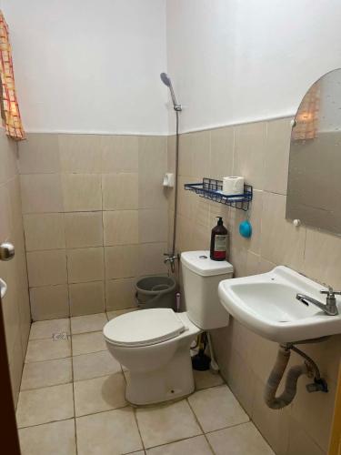 a bathroom with a toilet and a sink at Vin's Transient WiFi Netflix City Hall-DRMC-EPark in Tagum
