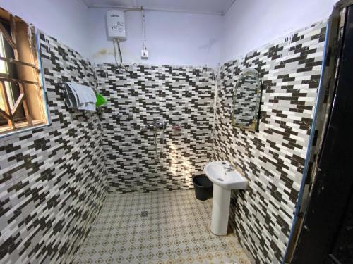a bathroom with a toilet and a sink at Savannah Lodge in Larabanga